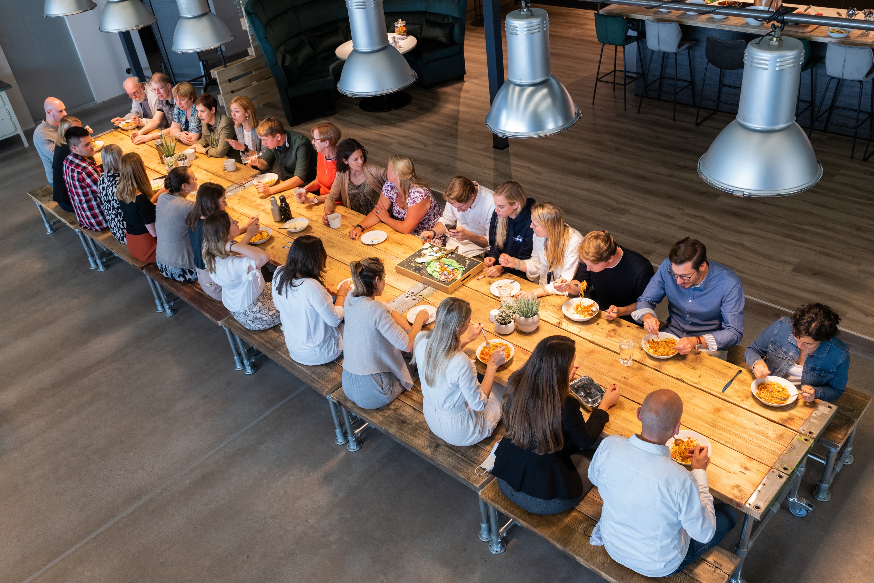 hitschler hitschies Team beim gemeinsamen Mittagessen im Büro in Hürth an einer langen Tafel 